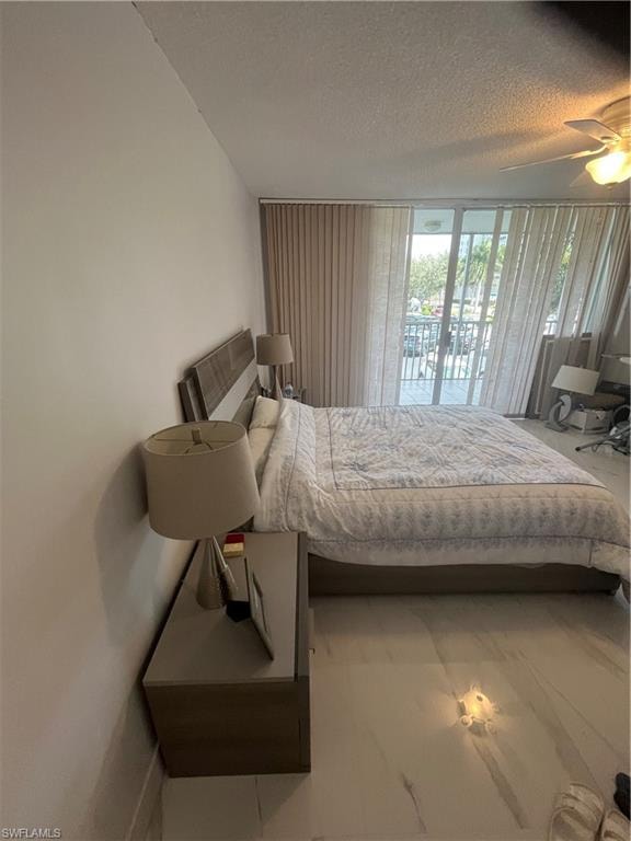 Bedroom featuring a textured ceiling, access to outside, and a ceiling fan