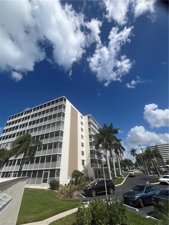 View of apartment building / complex featuring uncovered parking