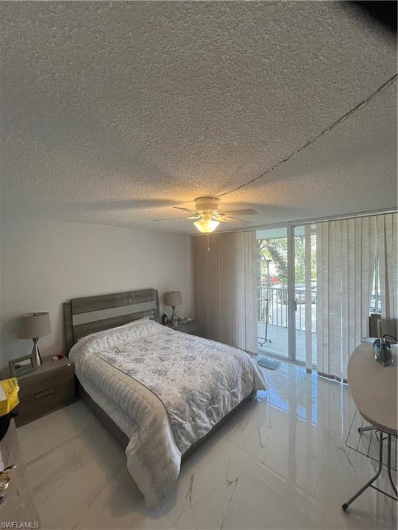 Bedroom featuring access to outside, ceiling fan, a textured ceiling, and expansive windows
