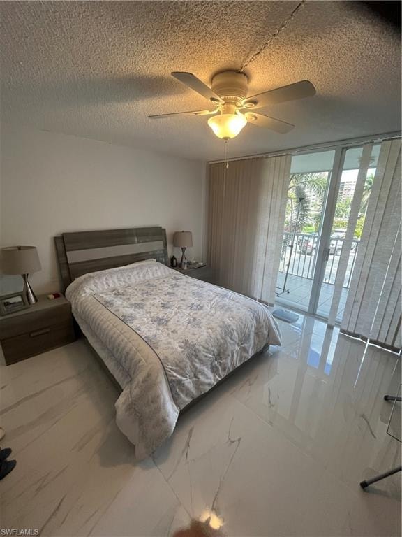 Bedroom featuring access to exterior, a textured ceiling, a ceiling fan, and expansive windows