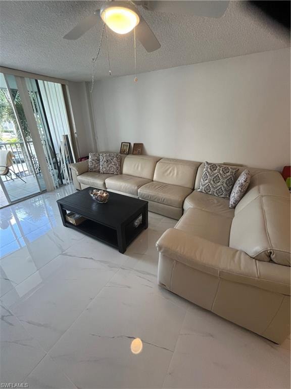 Living room with floor to ceiling windows, a textured ceiling, and ceiling fan