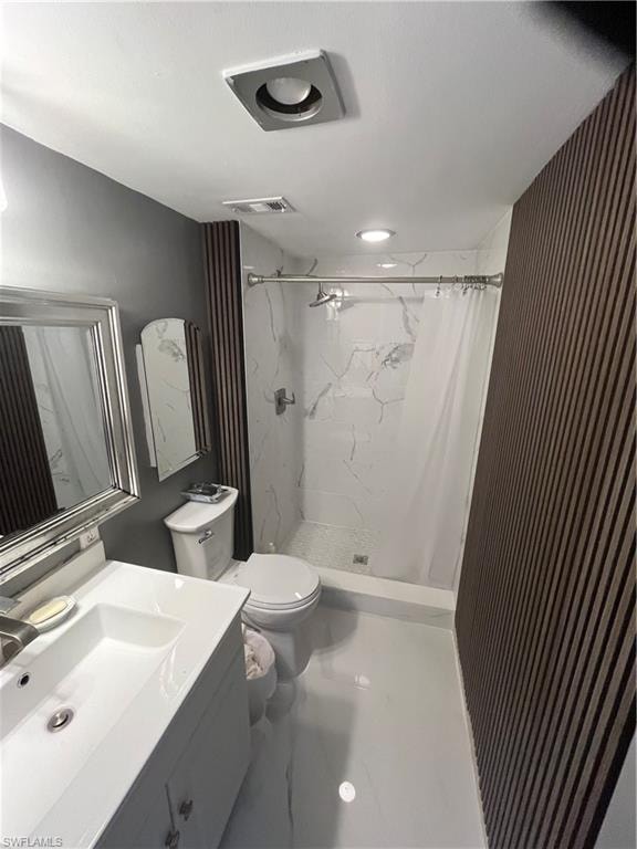 Bathroom featuring vanity and a marble finish shower