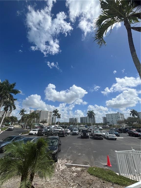 Uncovered parking lot featuring a view of city