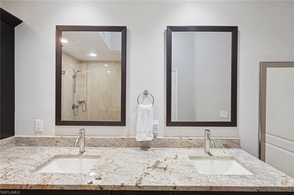 3/4 bath with double vanity and a stall shower