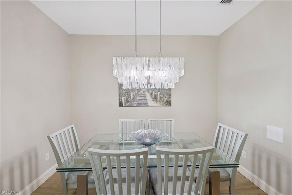 Dining area with wood finished floors and suspended lighting