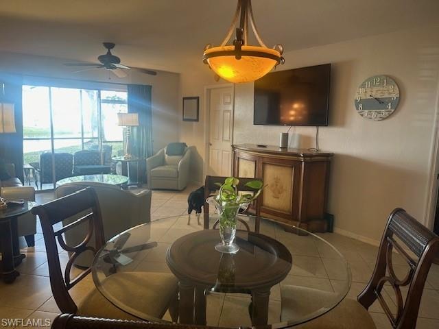 Dining room to living room with tile floors, large screen TV and a ceiling fan