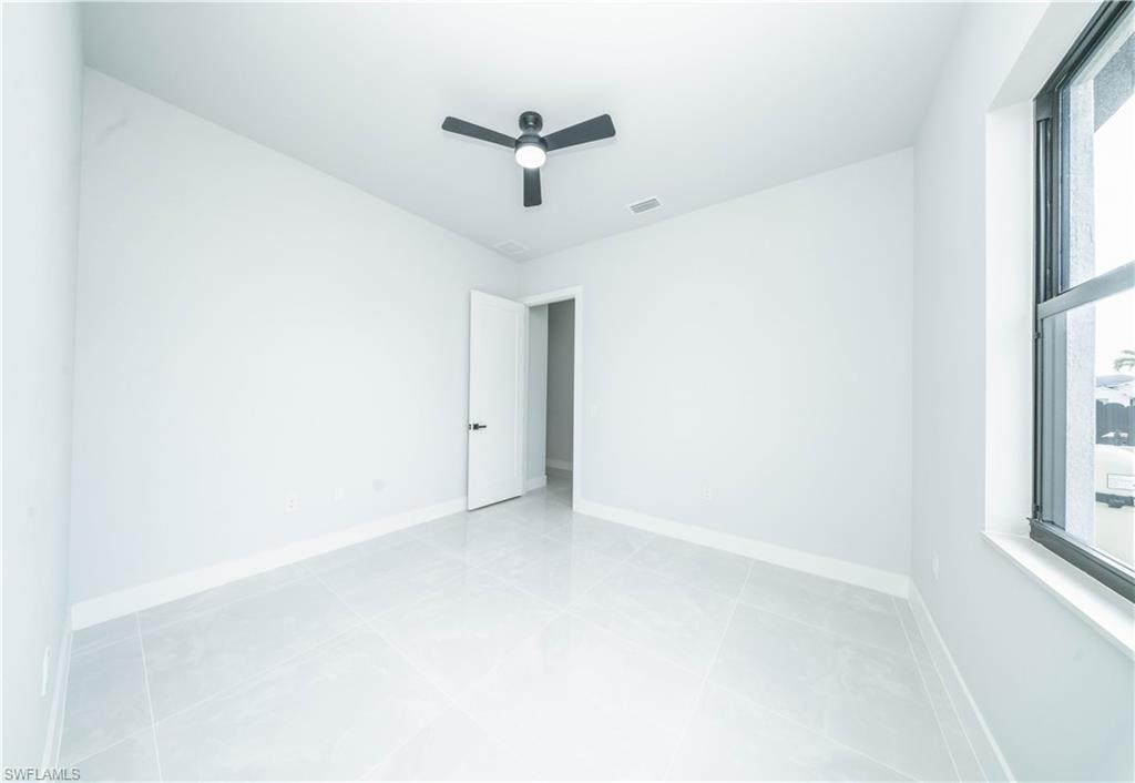 Unfurnished room l featuring ceiling fan and light tile patterned floors