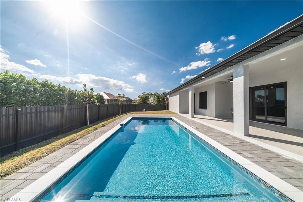View of swimming pool featuring patio surround and a fenced backyard
