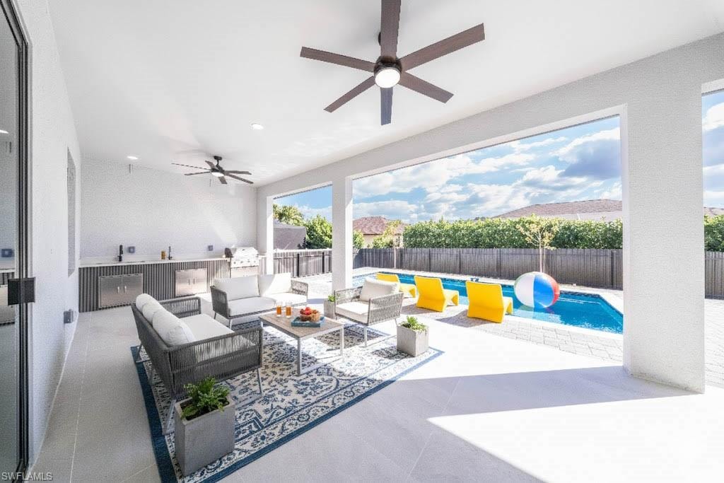View of swimming pool featuring exterior kitchen, patio surround, and a fenced backyard