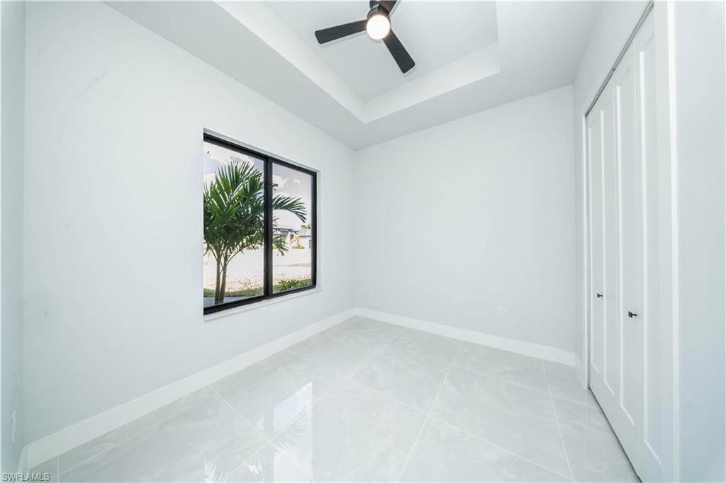 Empty room with baseboards and ceiling fan