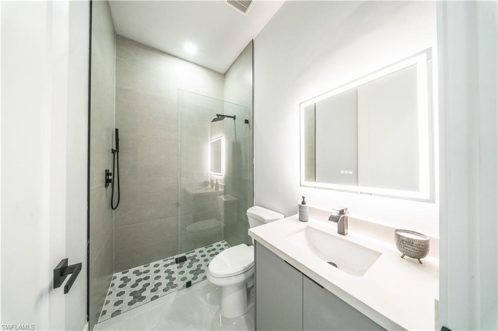 Full bath with vanity, walk in shower, and recessed lighting