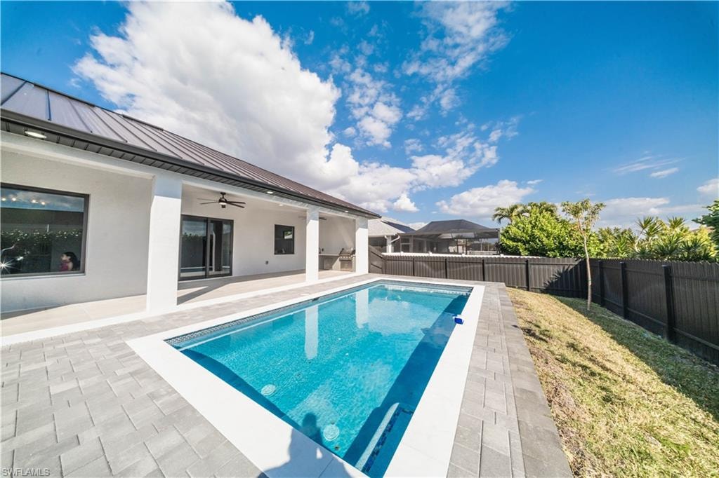 View of swimming pool with patio surround and a fenced backyard