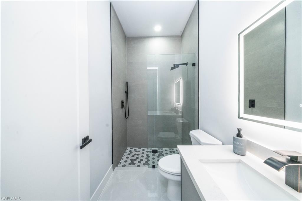 Bathroom with vanity and a stall shower l