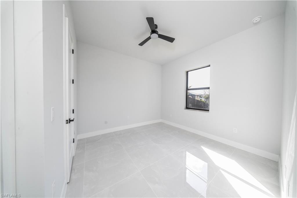 Spare room featuring ceiling fan and light tile patterned floors