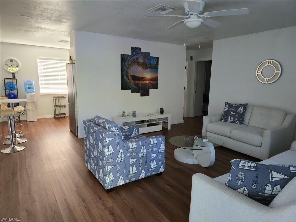 Living area featuring dark wood finished floors and a ceiling fan
