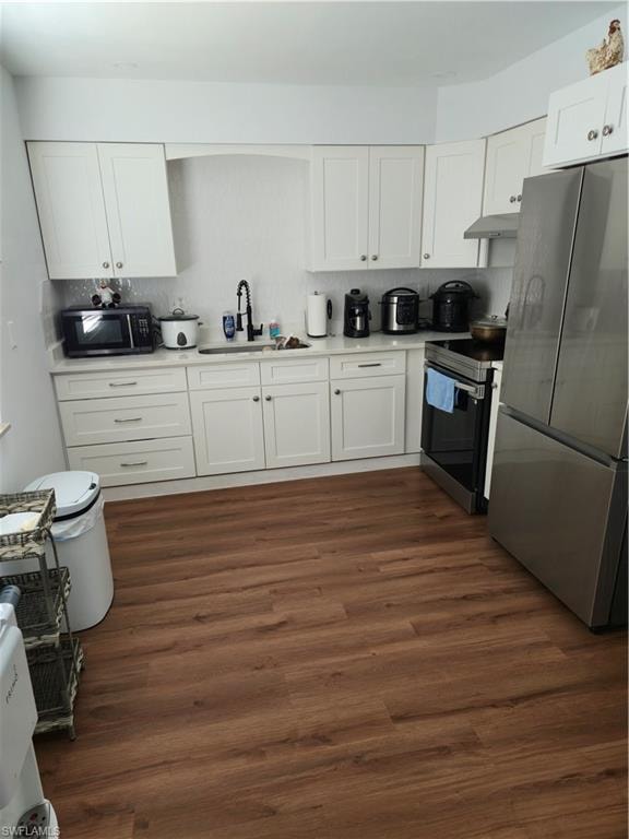 Kitchen featuring white cabinetry, refrigerator, range, and dark wood-style floors