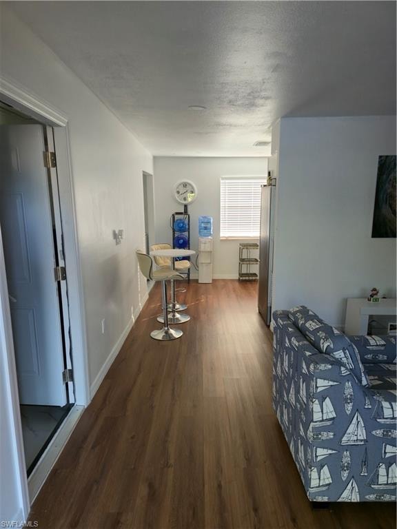 Bedroom with dark wood-style flooring, fridge, and a textured ceiling