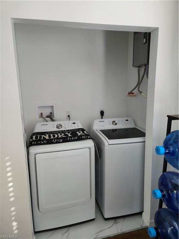 Laundry area with washing machine and clothes dryer and water heater