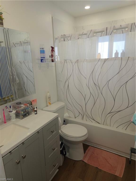 Bathroom featuring vanity, dark wood-type flooring, and shower / bath combination with curtain