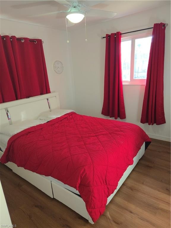 Bedroom with dark wood finished floors and a ceiling fan