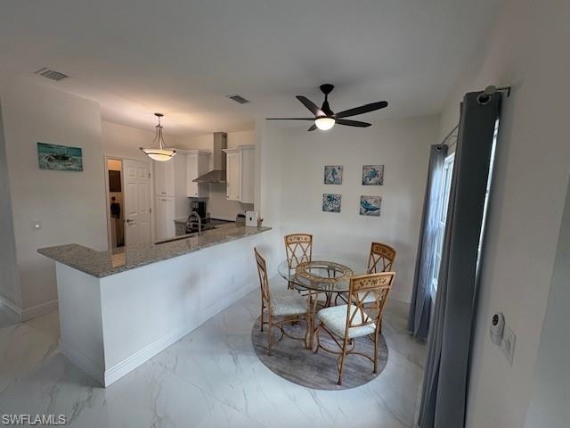 Dining area featuring light marble finish flooring and ceiling fan