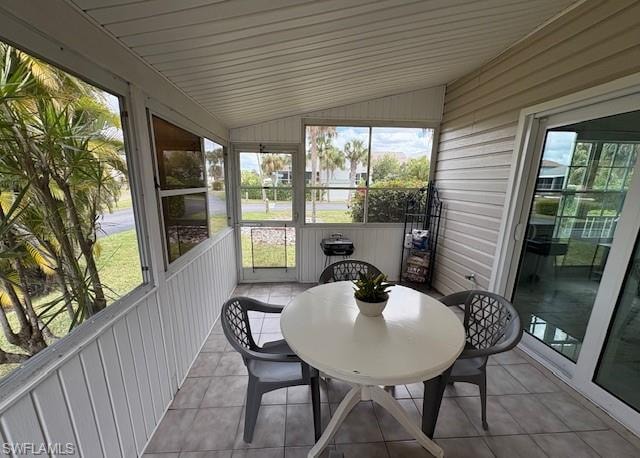 Sunroom featuring vaulted ceiling and outdoor dining space