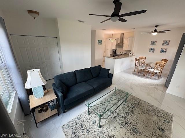 Living area with light marble finish flooring and ceiling fan