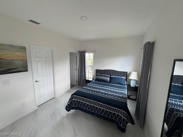 Bedroom featuring light marble finish floors and baseboards