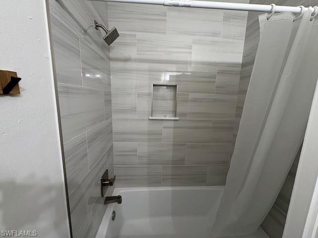 Full bath featuring shower / tub combo and a textured wall