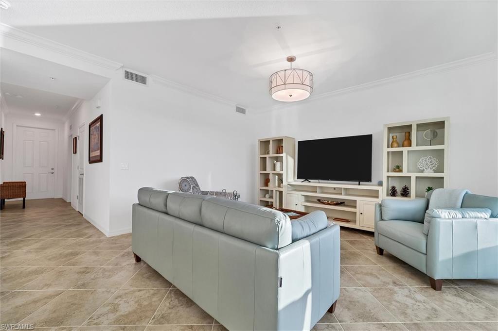 Living area with ornamental molding and light tile patterned floors