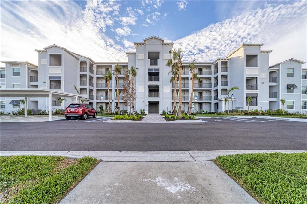 View of apartment building / complex with uncovered parking