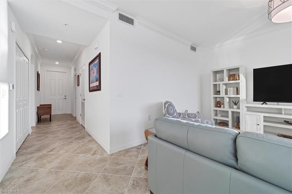 Living area featuring crown molding, light tile patterned floors, and recessed lighting