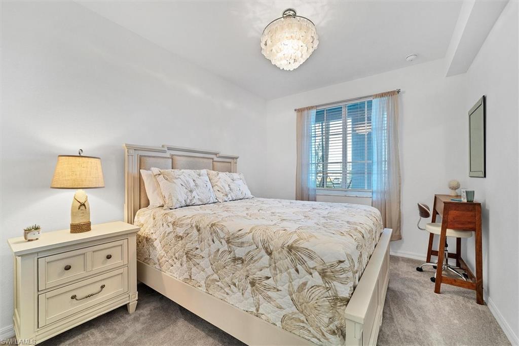 Bedroom with light colored carpet and baseboards