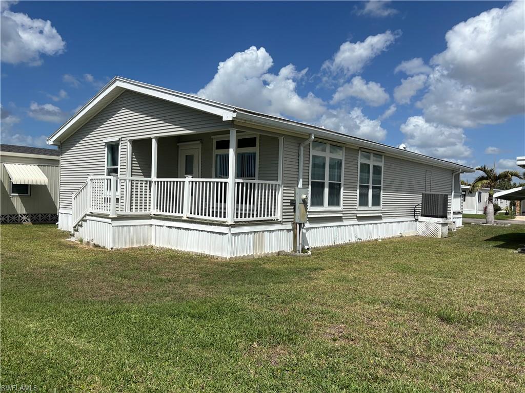 Rear view of property with a lawn and a porch