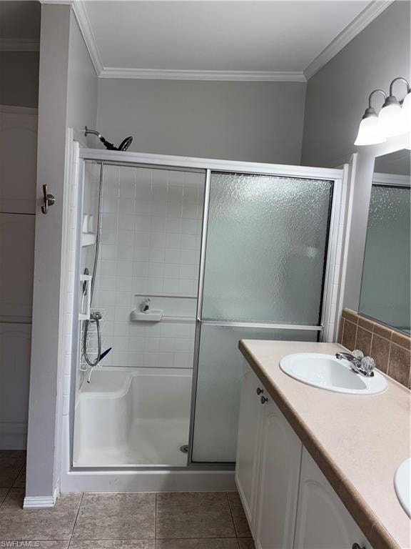 Bathroom with ornamental molding, a stall shower, double vanity, and light tile patterned floors