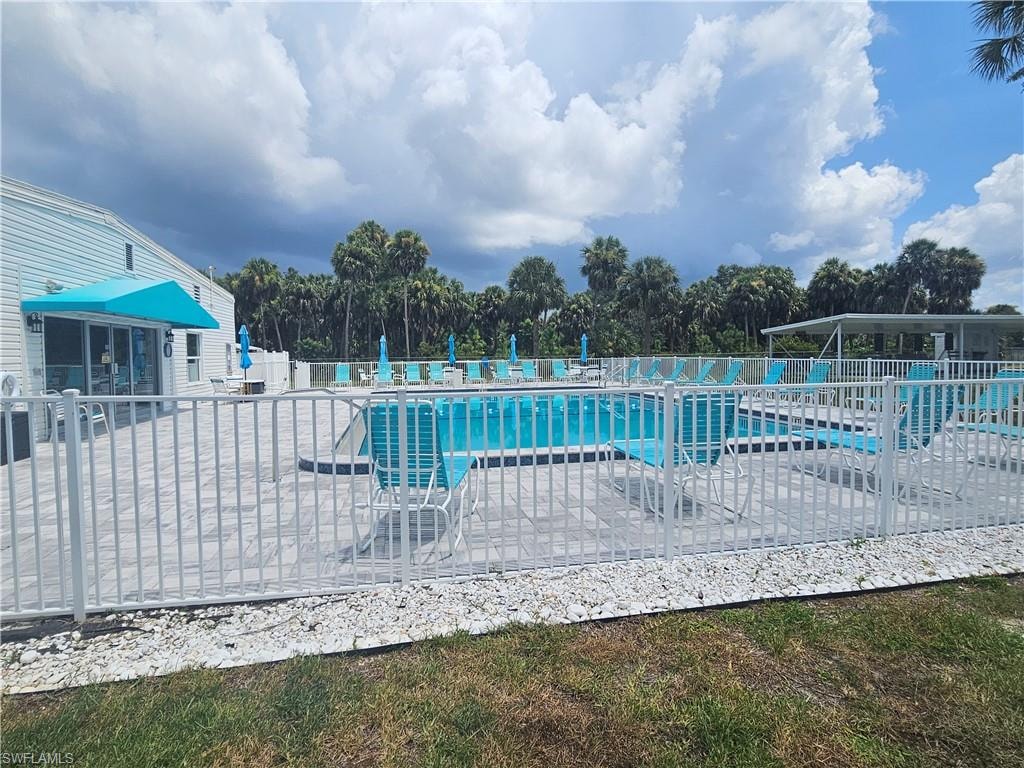 Community pool featuring a patio and view of scattered trees