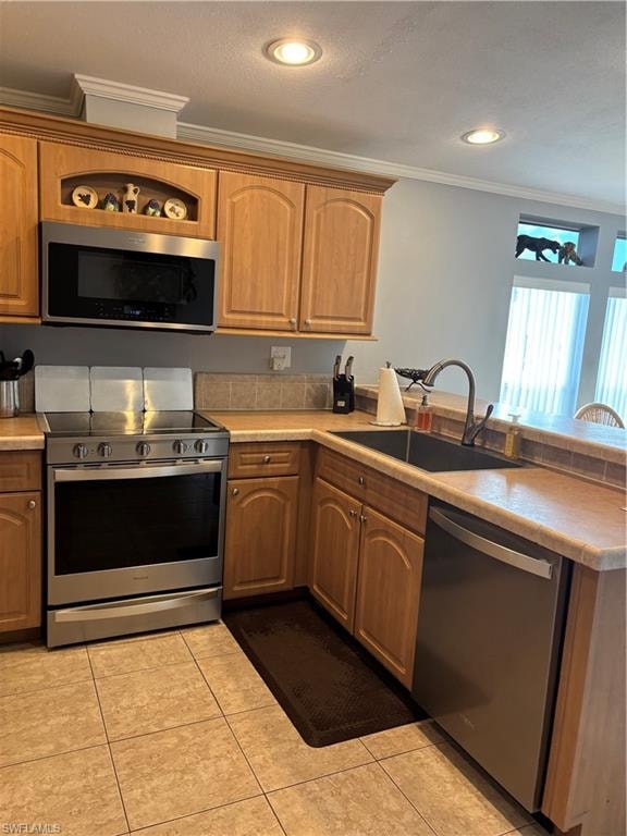 Kitchen with stainless steel appliances, ornamental molding, light countertops, light tile patterned floors, and a peninsula