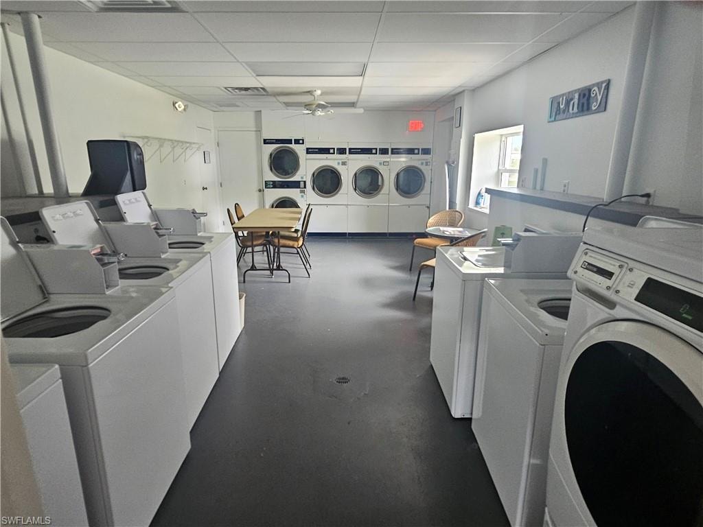 Community laundry room featuring ceiling fan, independent washer and dryer, and a paneled ceiling