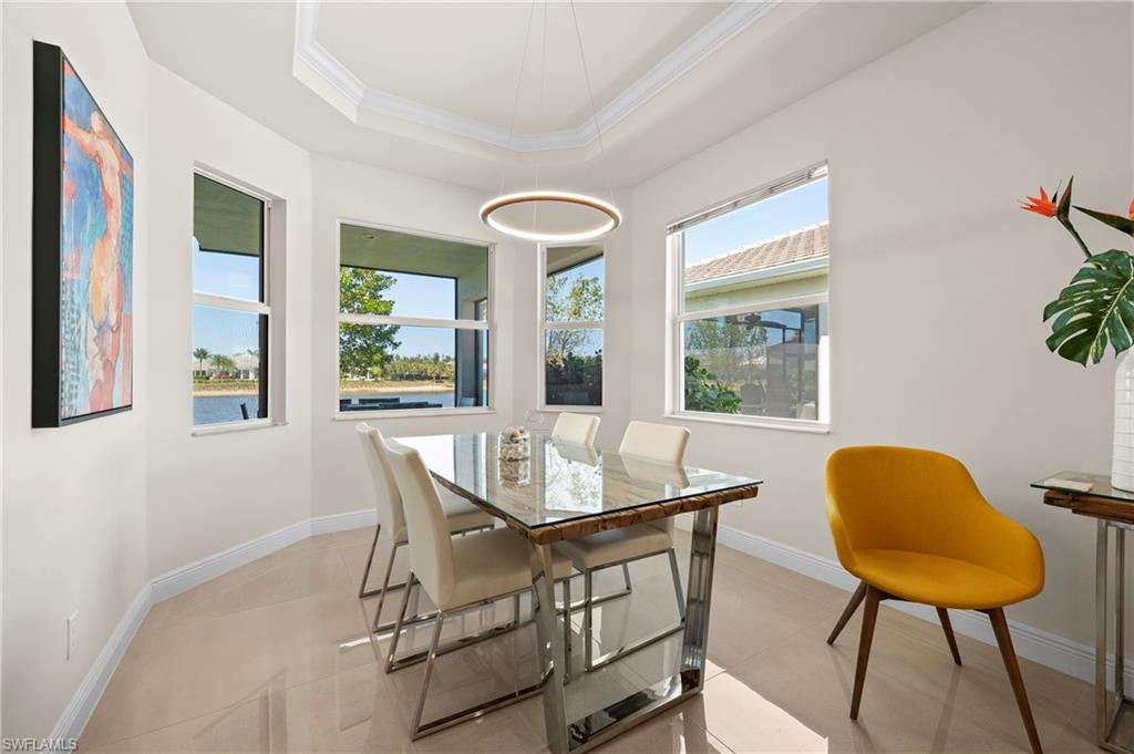 Dining area with plenty of natural light, ornamental molding, and a raised ceiling