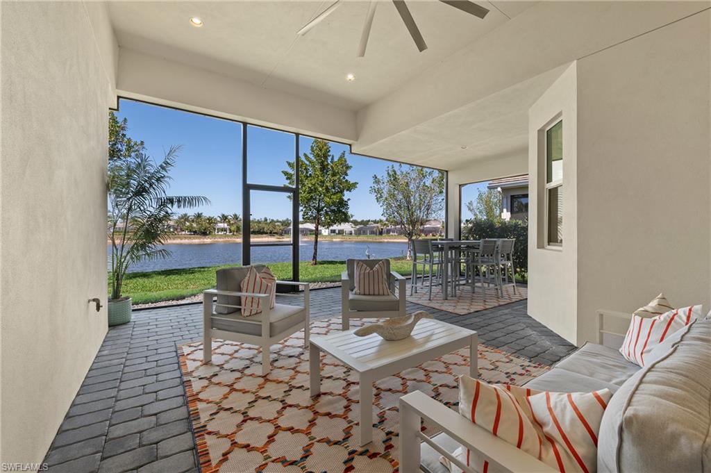 View of patio featuring a water view, a ceiling fan, and outdoor dining space