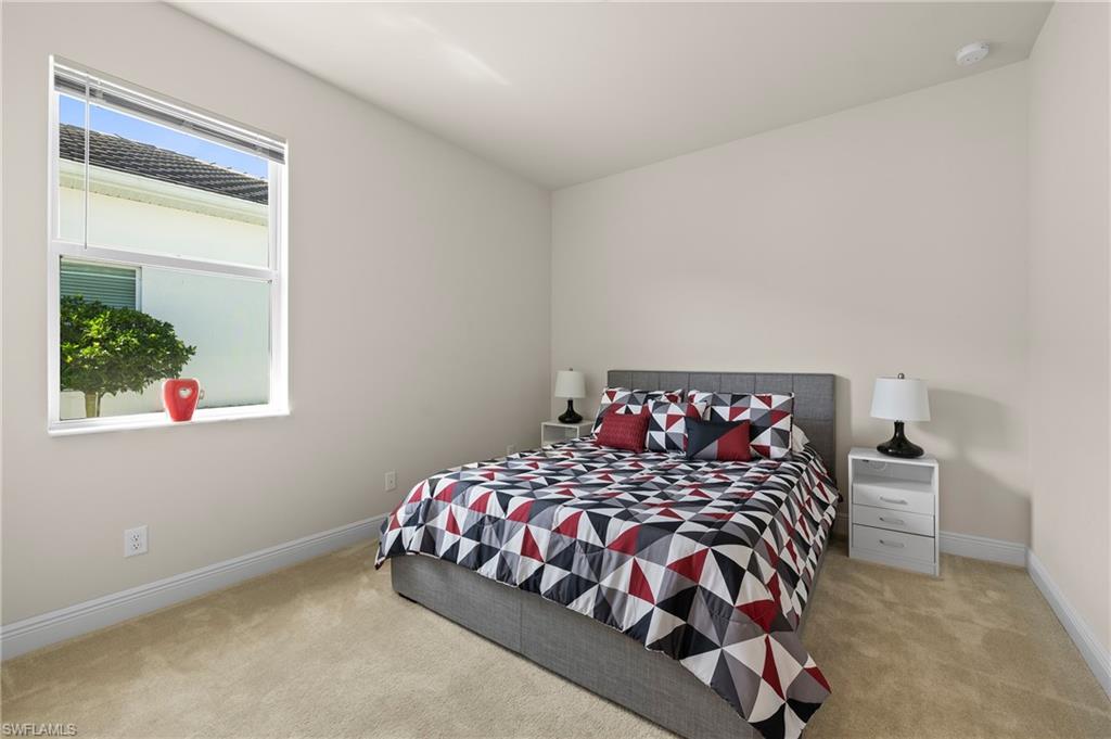 Bedroom with light carpet and baseboards