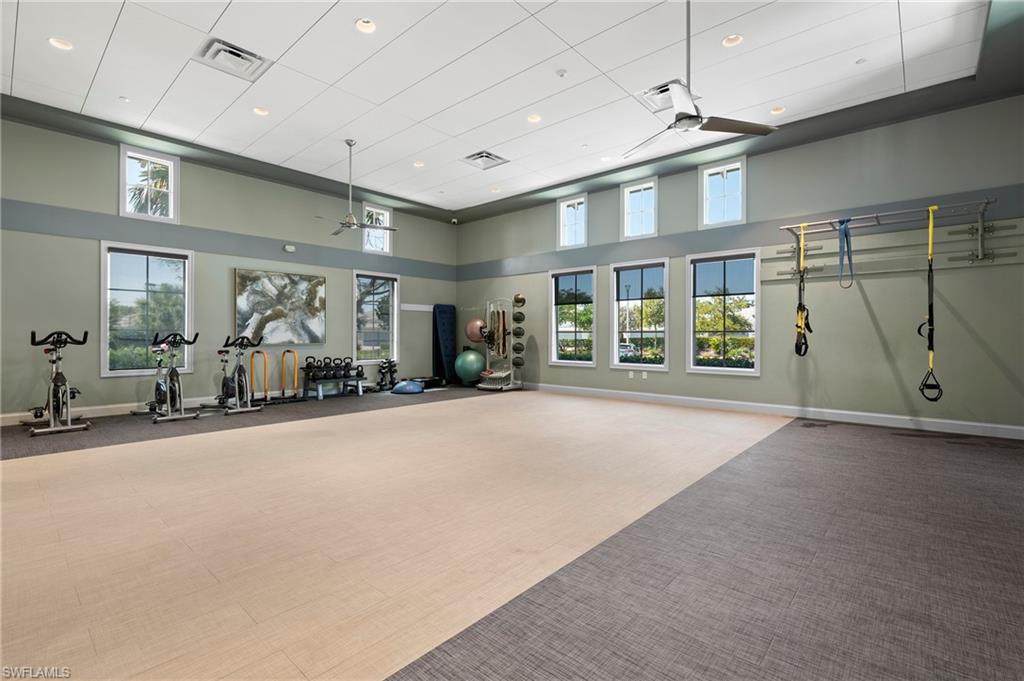 Exercise room with a high ceiling, ceiling fan, and recessed lighting