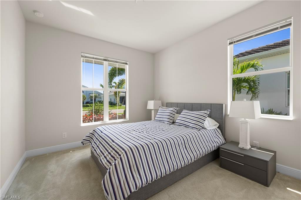 Bedroom featuring light carpet and baseboards
