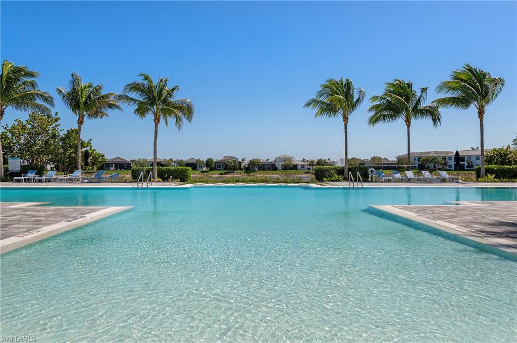Community pool with a patio area and a residential view