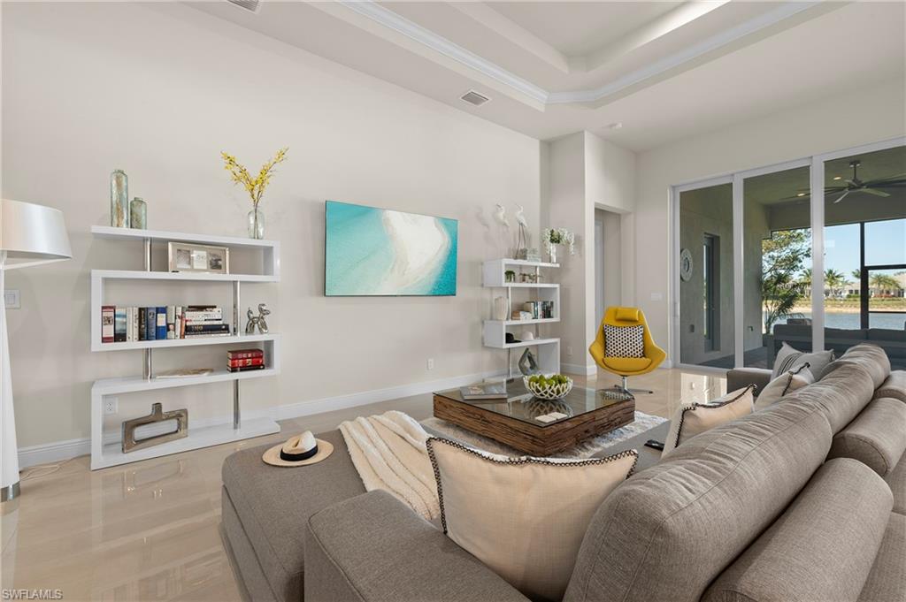 Living room featuring a tray ceiling and ceiling fan