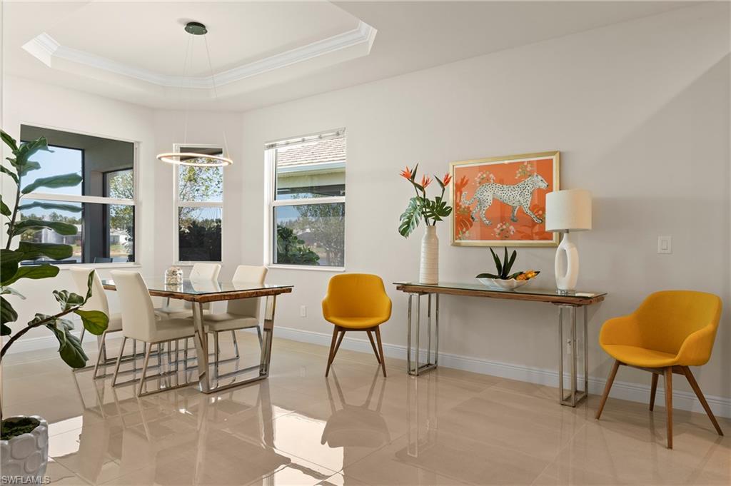 Dining space featuring plenty of natural light, a raised ceiling, and ornamental molding