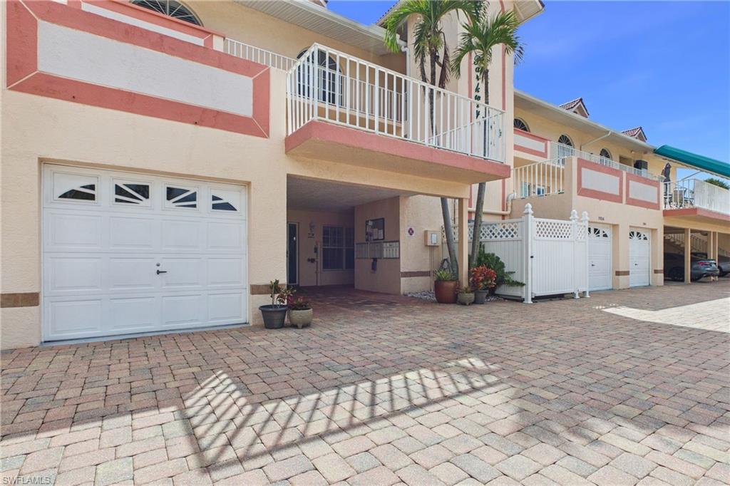 View of front of house with a balcony, stucco siding, and a garage