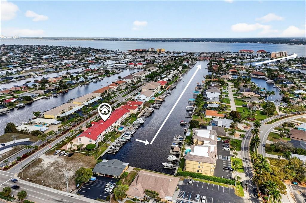Aerial view of property's location with a large body of water and nearby suburban area