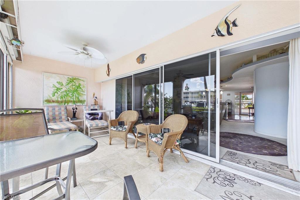 Sunroom with ceiling fan, a patio area, and outdoor furniture