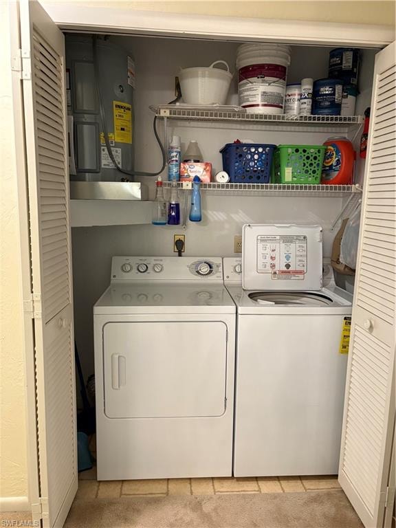 Laundry area featuring independent washer and dryer, water heater, and light carpet